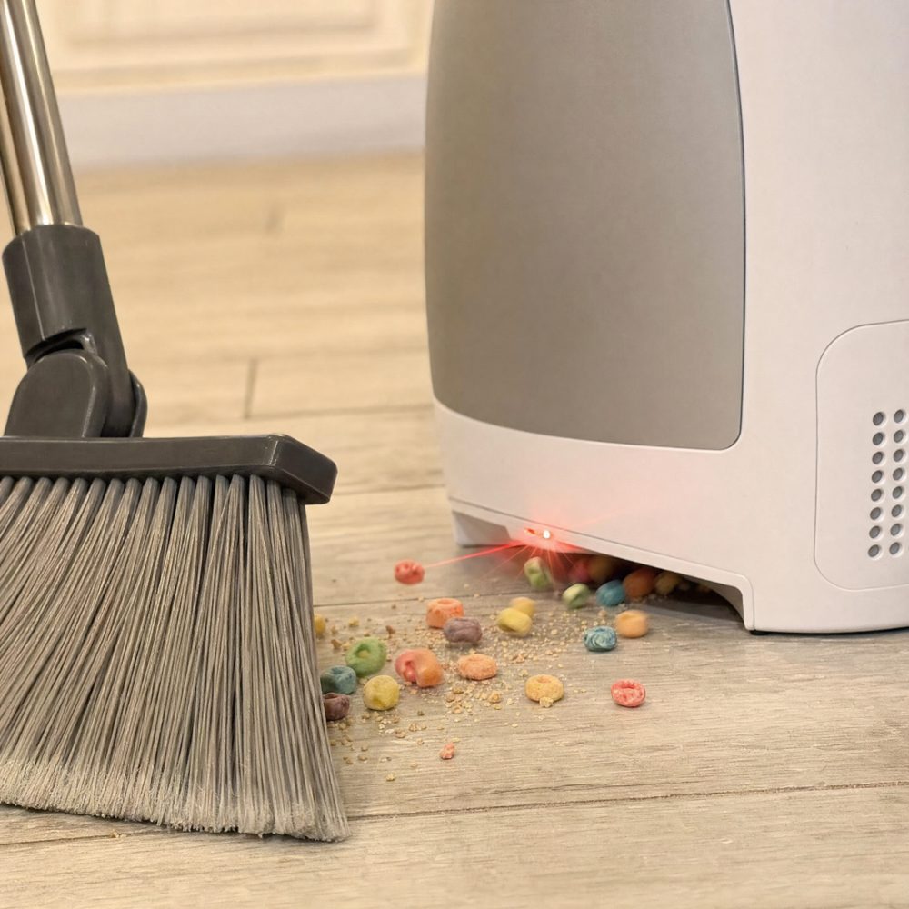 Close-up of the EyeVac sensor laser activating as a broom sweeps cereal toward it
