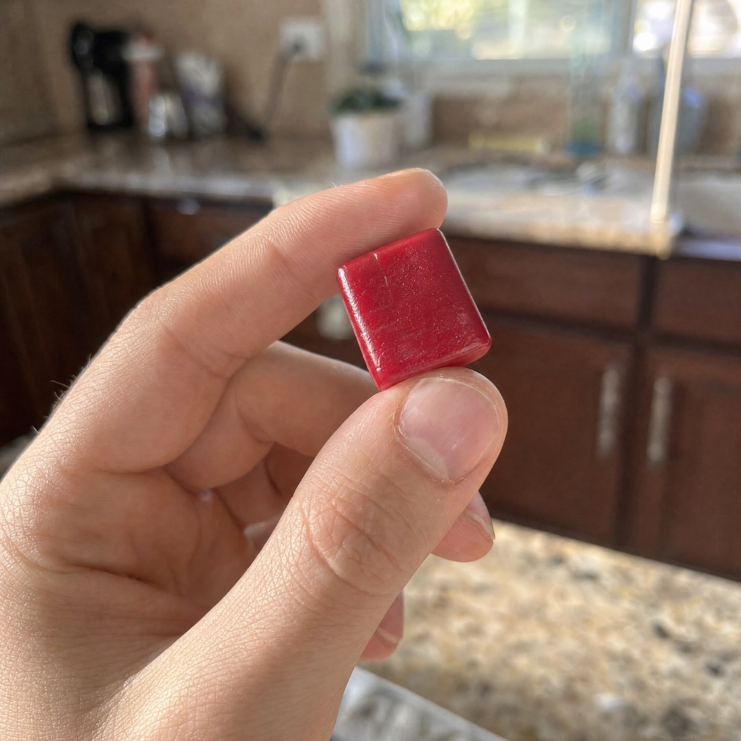 A single SuperBeets heart chew held between fingers