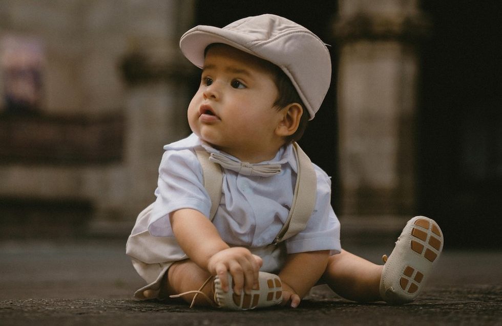 a baby boy with a news cap on