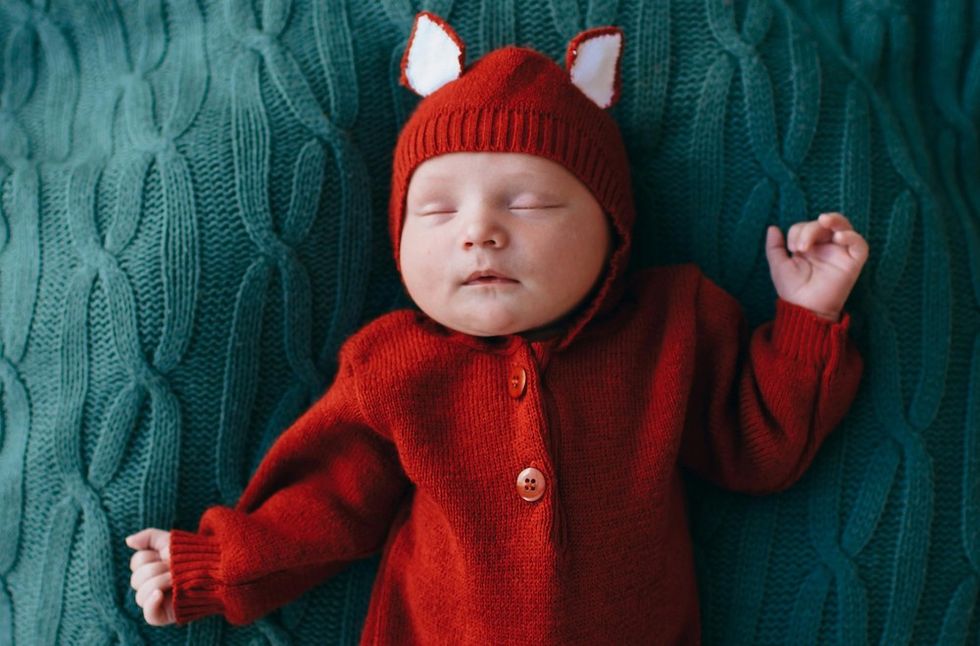a baby wearing a fox outfit