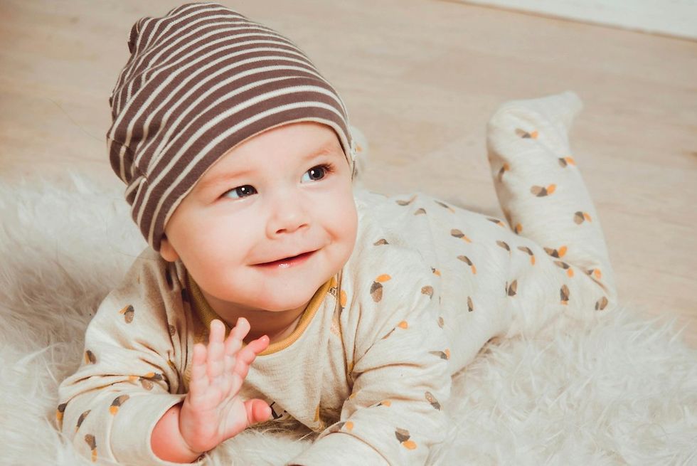 a baby wearing a hat and smiling