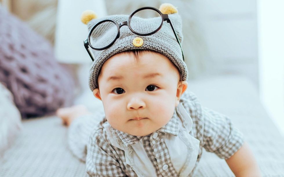 a baby with glasses and a hat