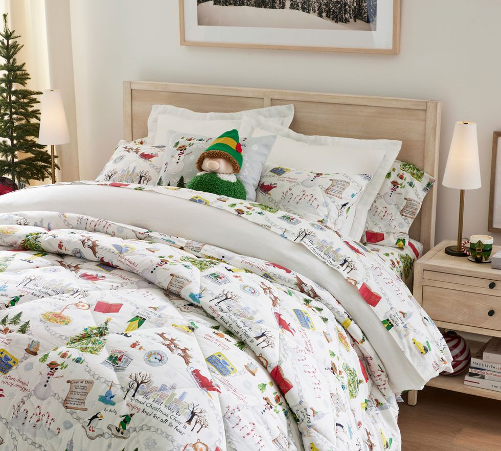 A bed is made with the PB x Elf comforter and sheet set.