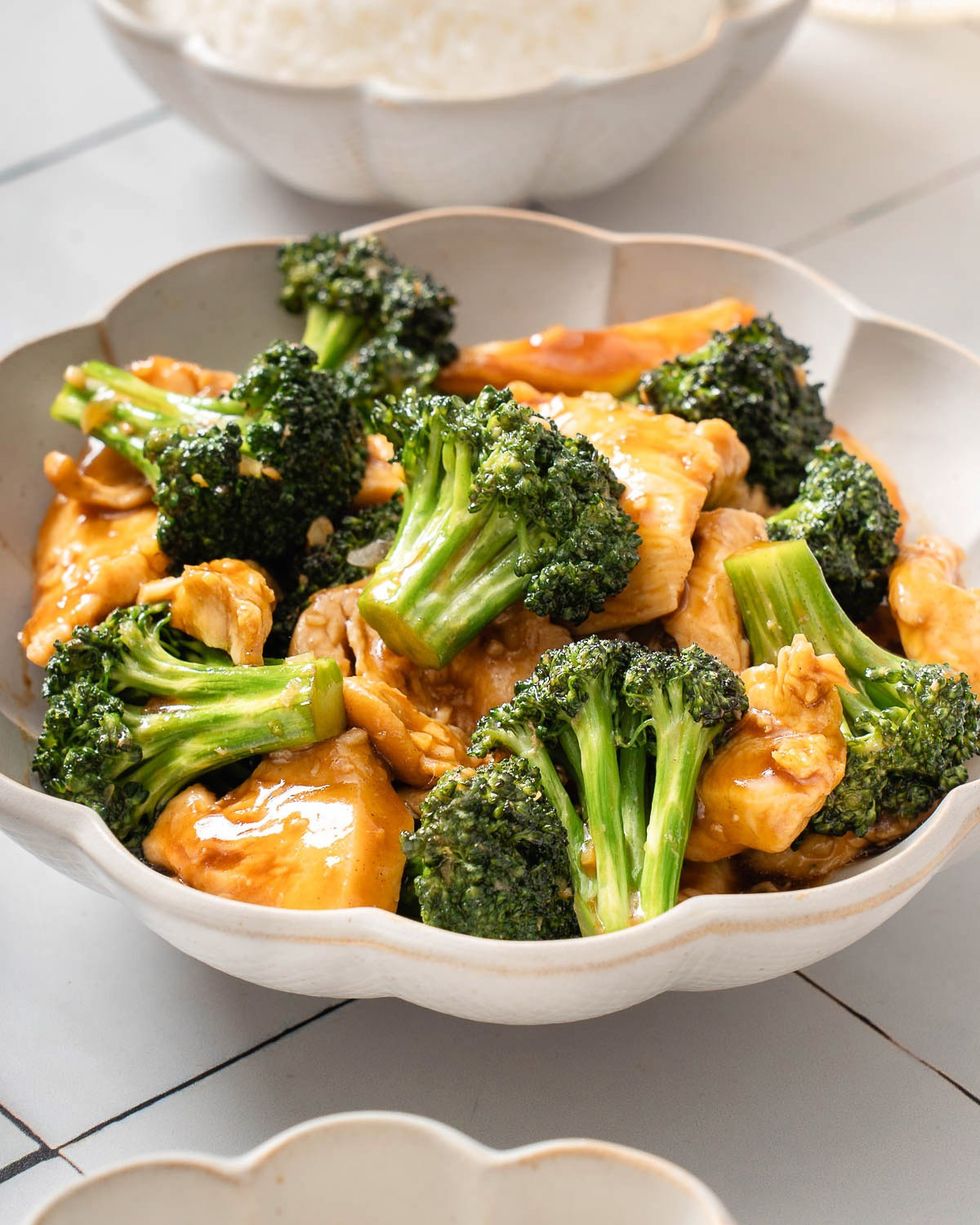 A bowl of Chinese chicken and broccoli sits in a bowl.
