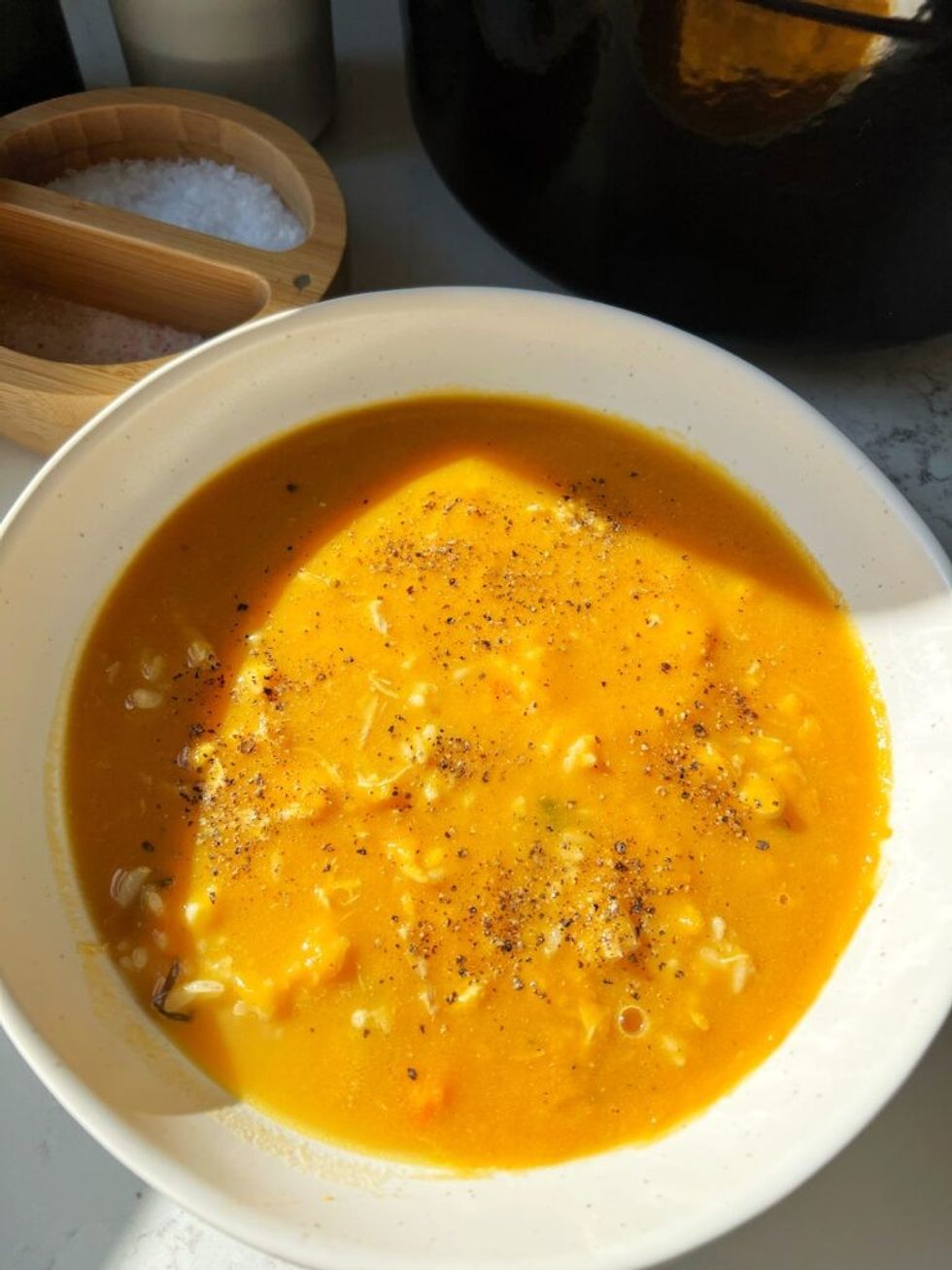 A bowl of homemade chicken soup is sitting in a white bowl.
