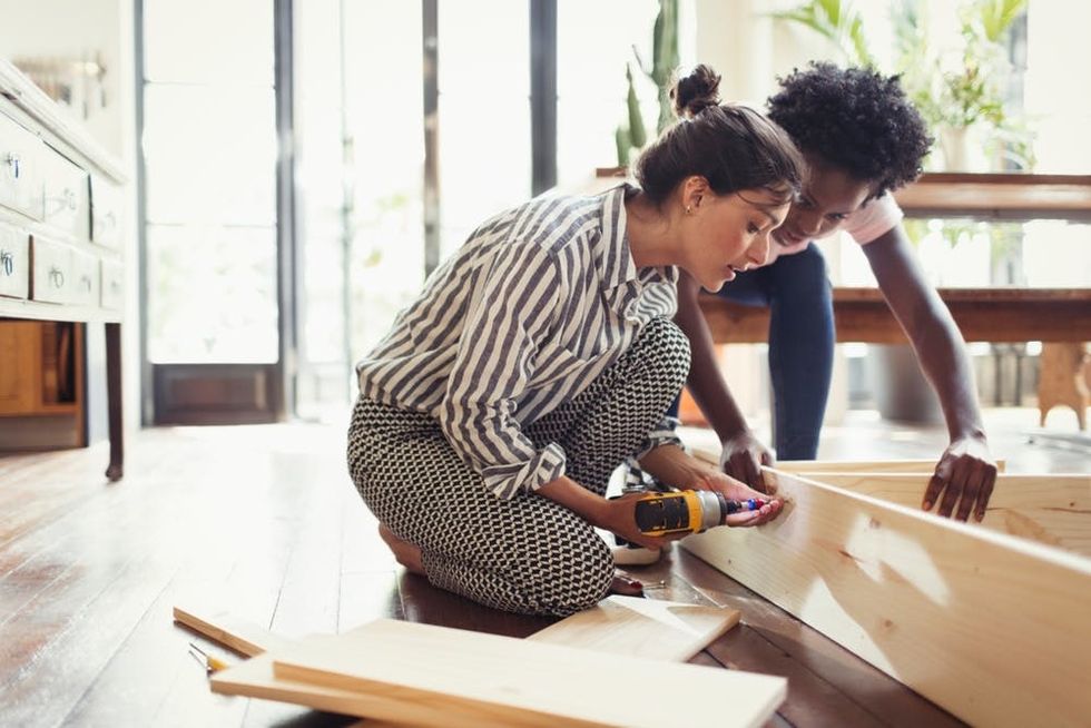 A couple assembles a shelf together