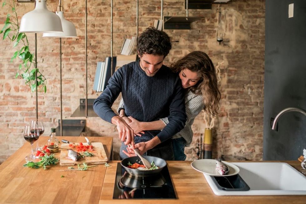 A couple cooks dinner together