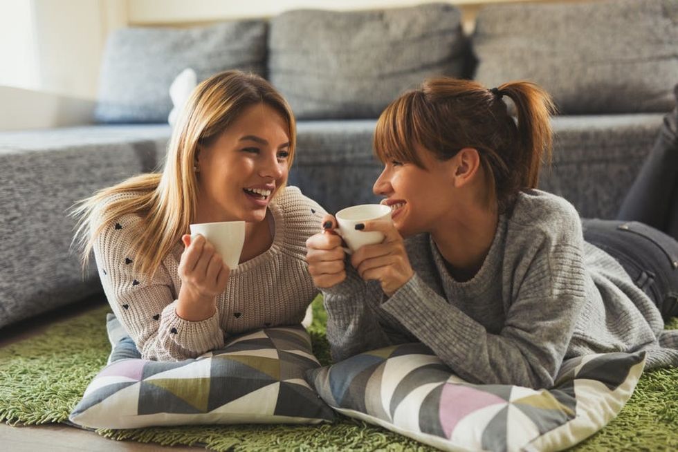 A couple drinks coffee together in their living room