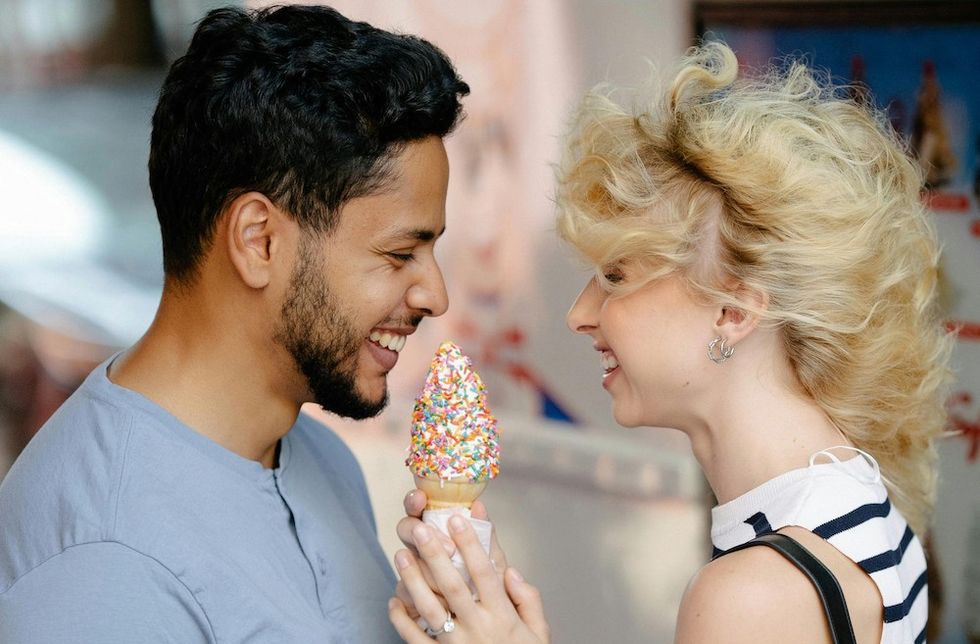 a couple sharing a soft serve ice cream cone