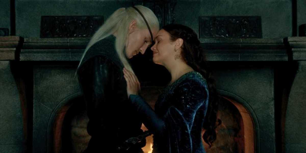 a couple stands together before a fireplace