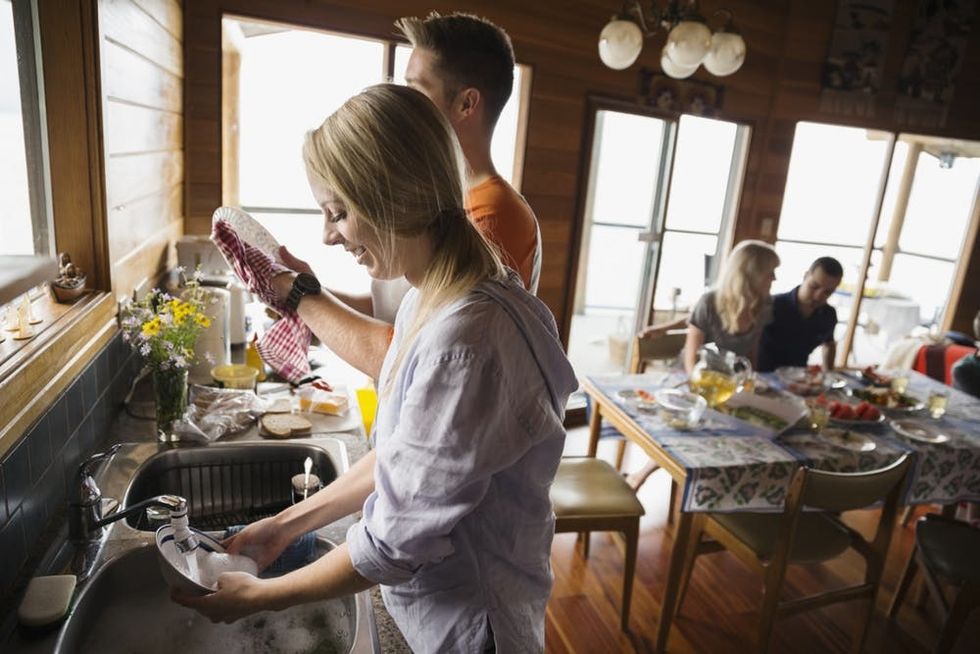 A couple washes dishes together