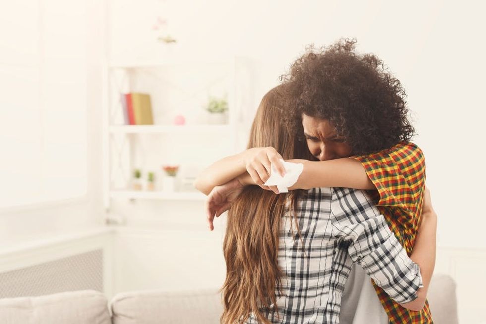 A crying woman hugs her friend