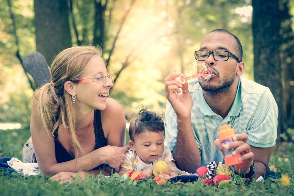 A family blows bubbles together in a park