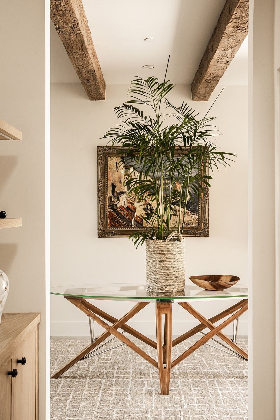 a glass table in an entryway with exposed beams