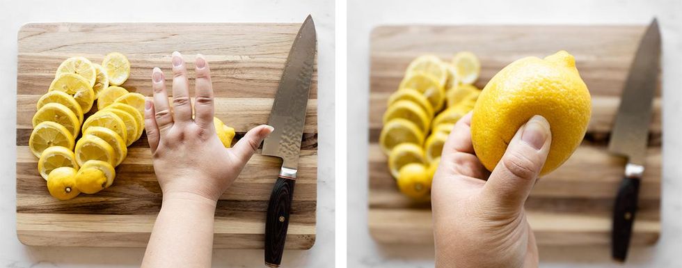 A hand rolls a lemon on a cutting board and squeezes it for softness