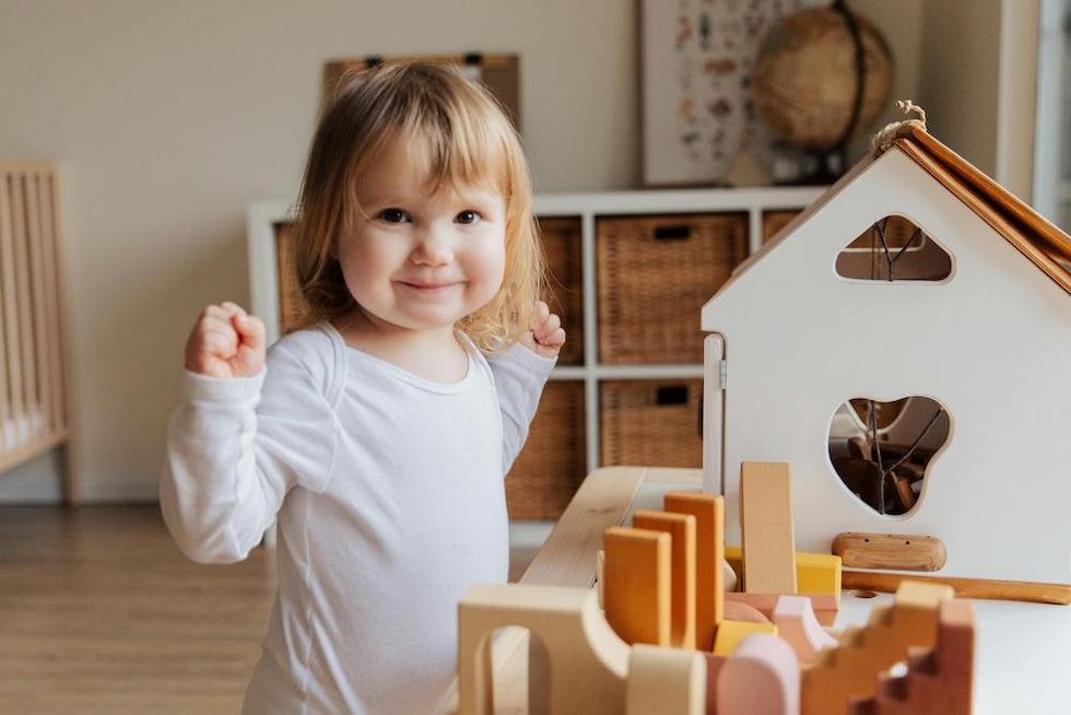 a happy baby playing with her toys