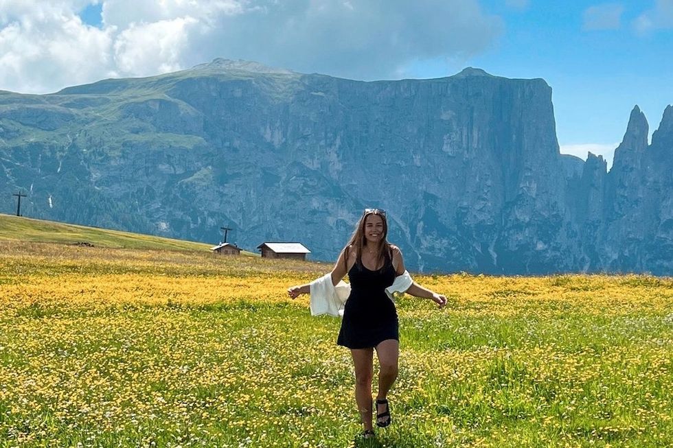 a happy woman walking in a field of wildflowers
