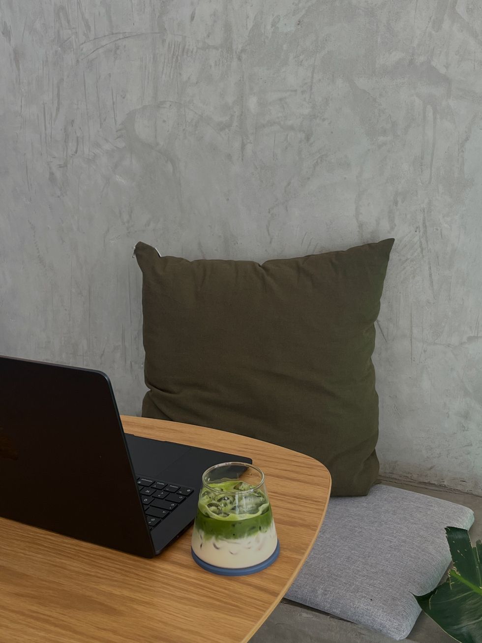 a laptop and an iced matcha latte at a coffee shop