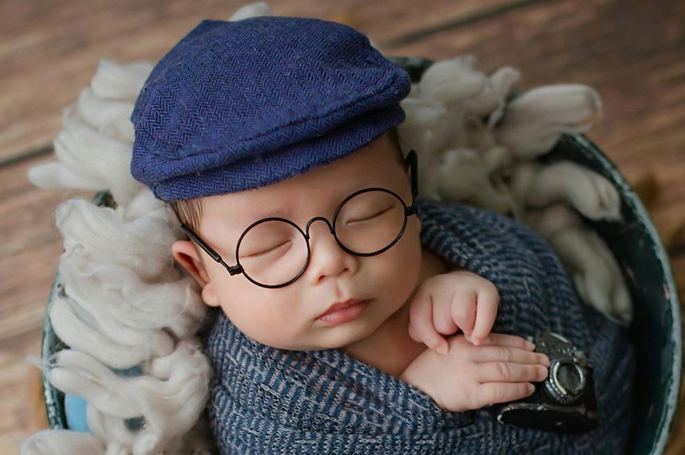 a little boy with a news cap and glasses on
