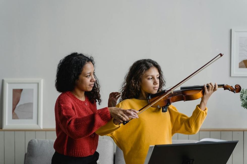 a mother and a daughter practicing violin