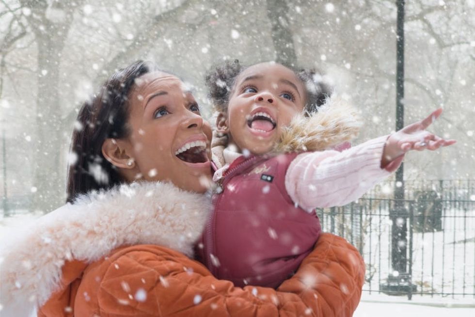 A mother and daughter enjoy falling snow