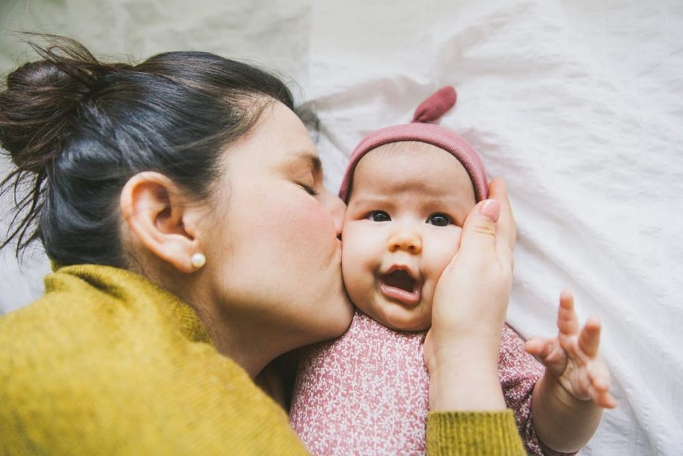 A mother kisses her baby