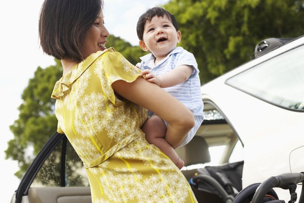 A mother puts her baby into the car