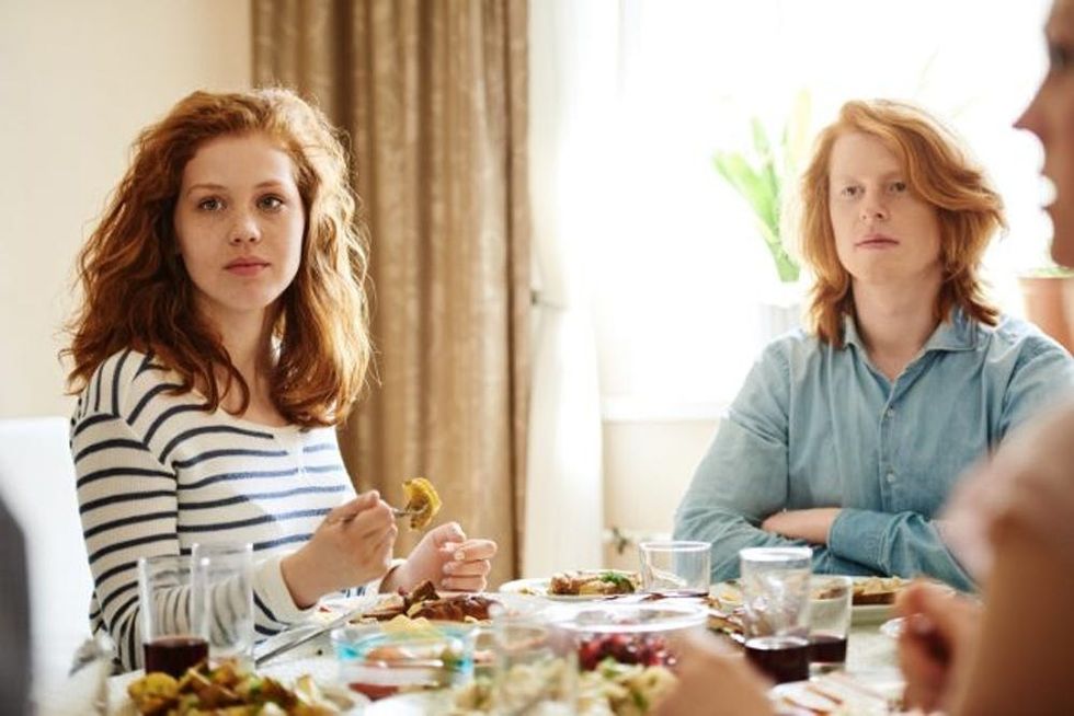 A pair of siblings eat dinner together