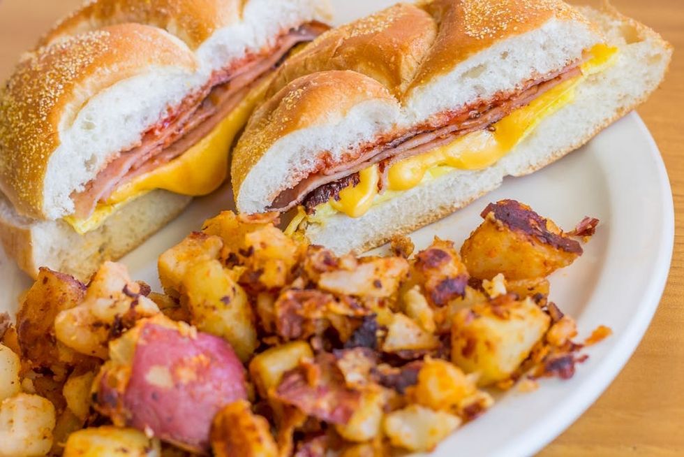 A pork roll breakfast sandwich is served with a side of home fries
