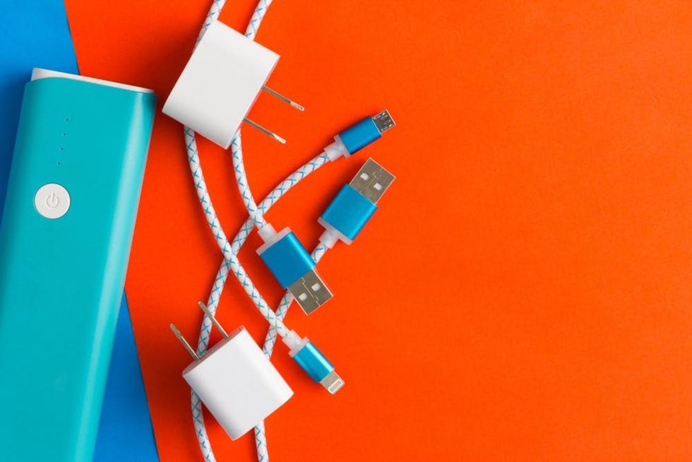 A power bank and charging cables sit on a brightly colored surface