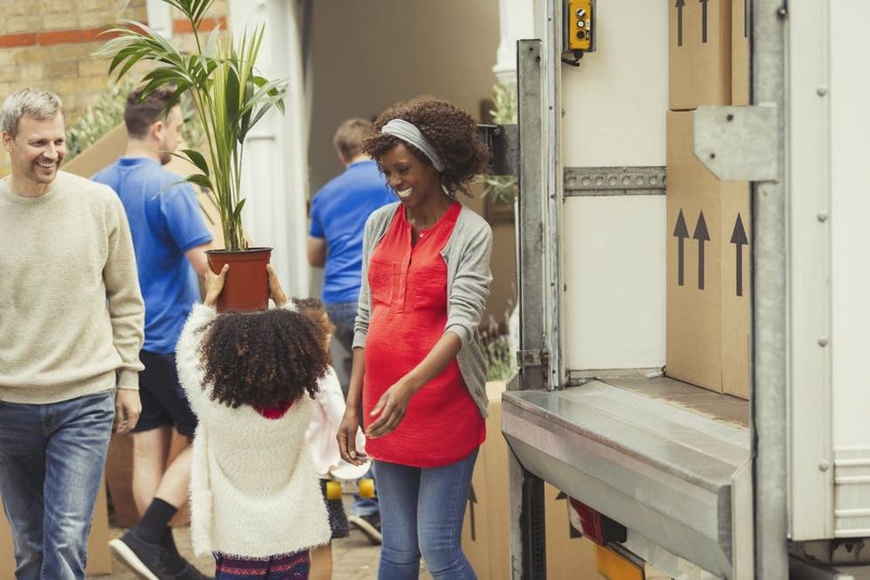 A pregnant woman and her family move to a new home