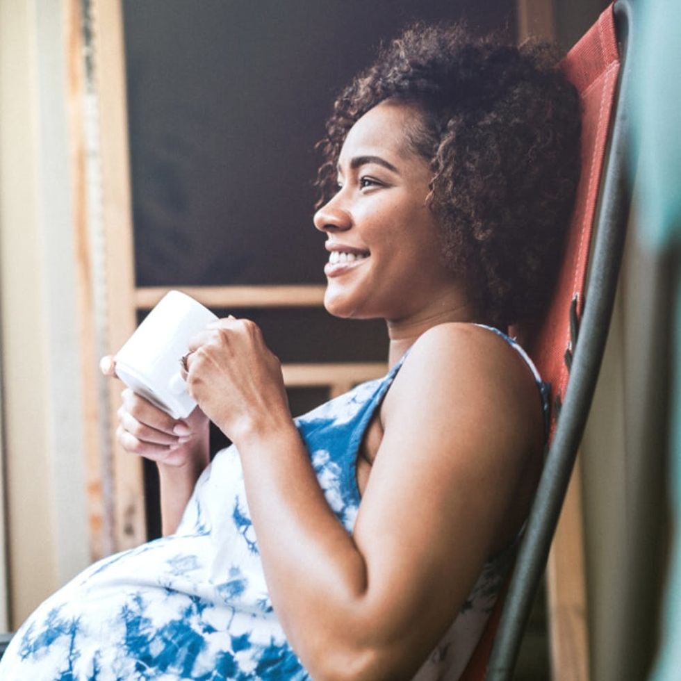 A pregnant woman relaxes with a mug of tea