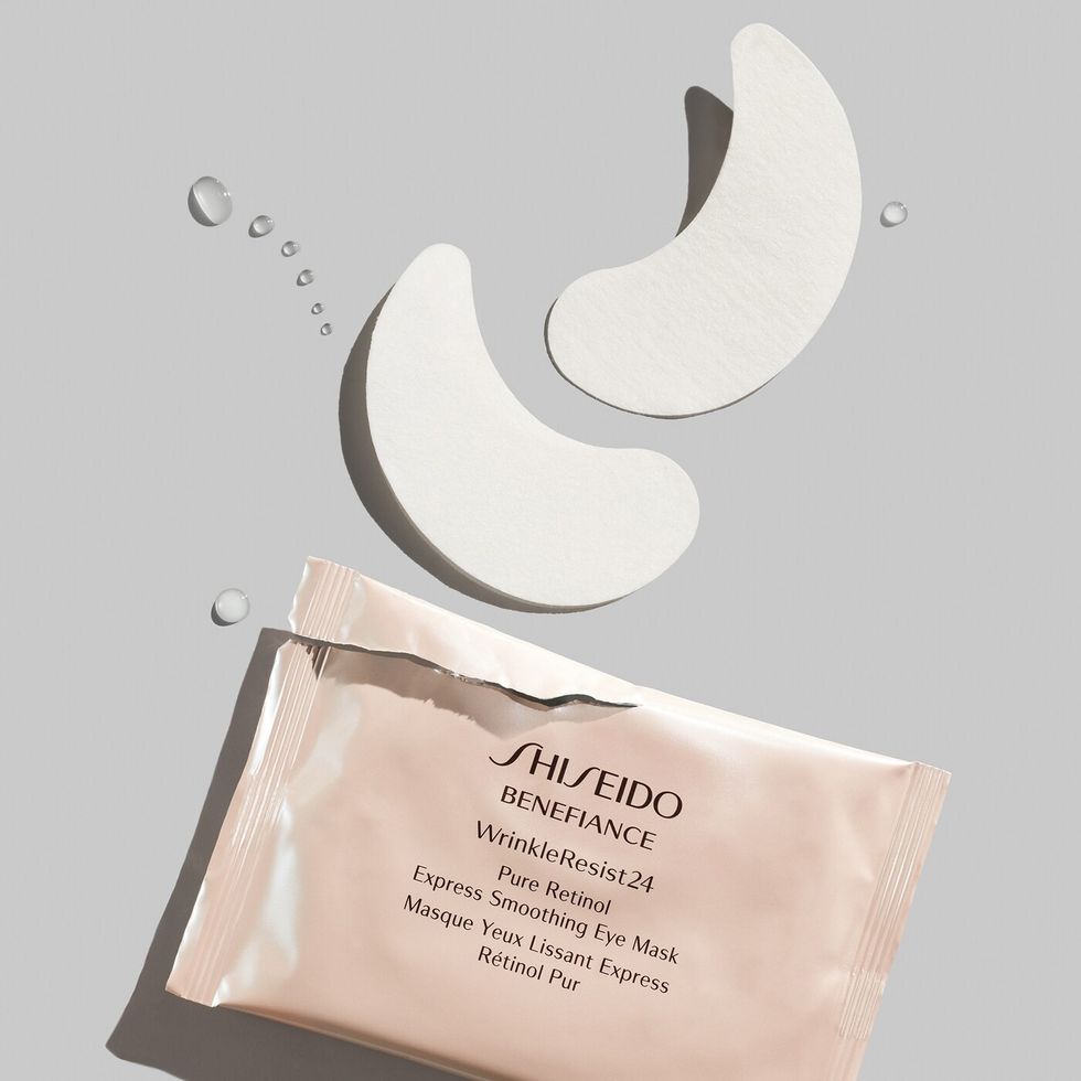 A ripped open package of Shiseido eye patches is on a gray background.