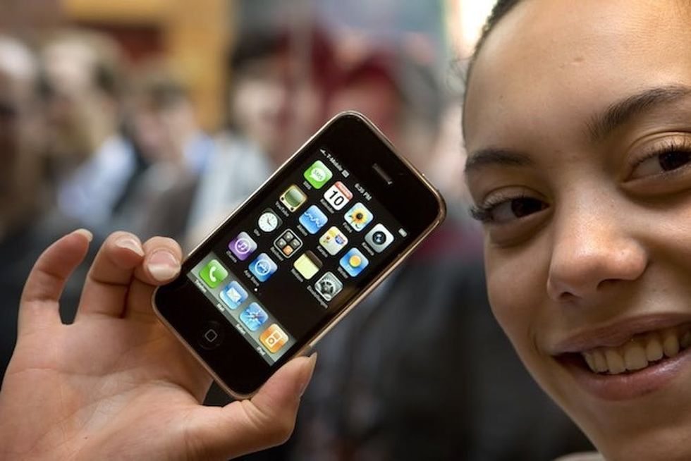 A shop assistant shows the new iPhone 3G in a shop in Amsterdam on July 11, 2008. Apple Inc.'s 3G wireless connecting iPhone went on sale in more than 22 countries on July 11. AFP PHOTO / MARCEL ANTONISSE -netherlands out - belgium out- (Photo credit should read MARCEL ANTONISSE/AFP/Getty Images)