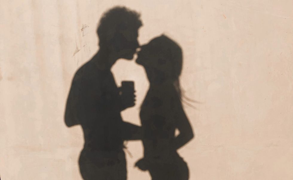 a silhouette of a couple kissing