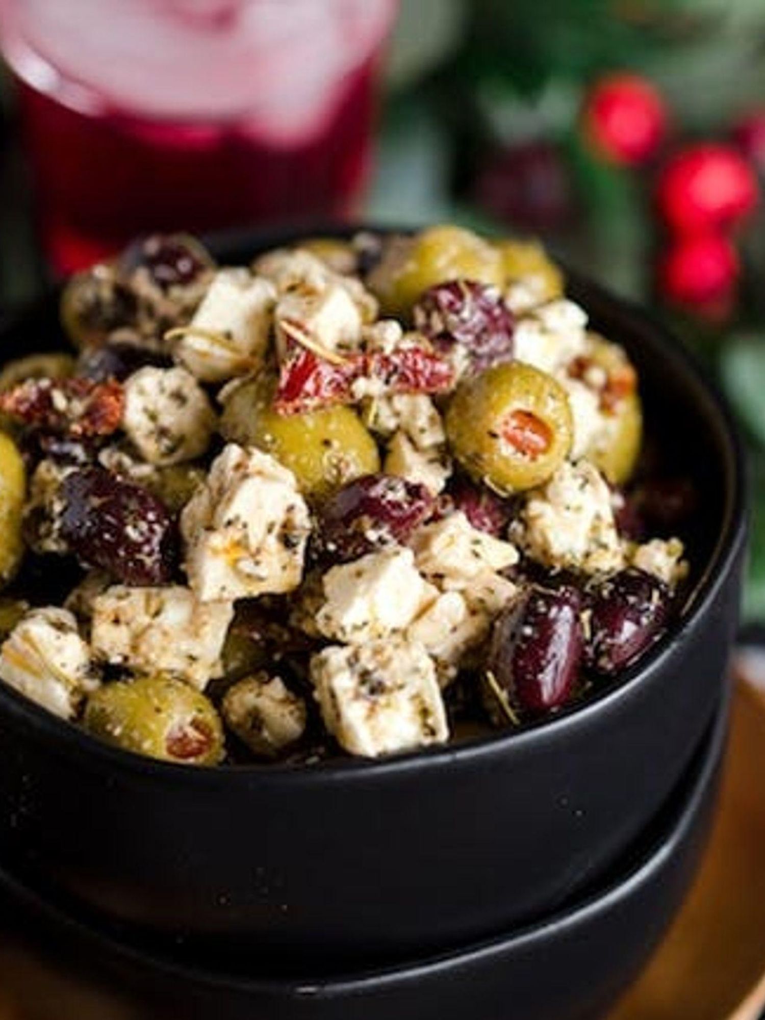 A small black bowl of Citrus Marinated Olives and Feta