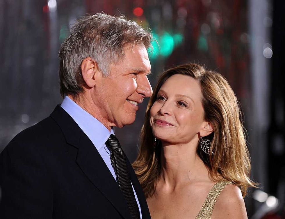 A smiling couple dressed in formal attire, sharing an affectionate moment at an event.