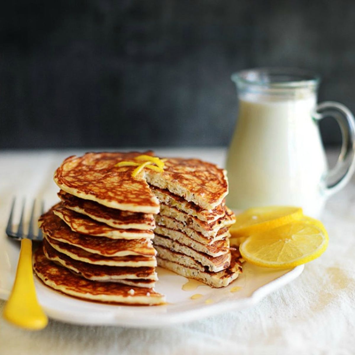 A stack of chia seed pancakes on a white plate with lemon slices is one of 25 healthy chia seed recipes to explore.