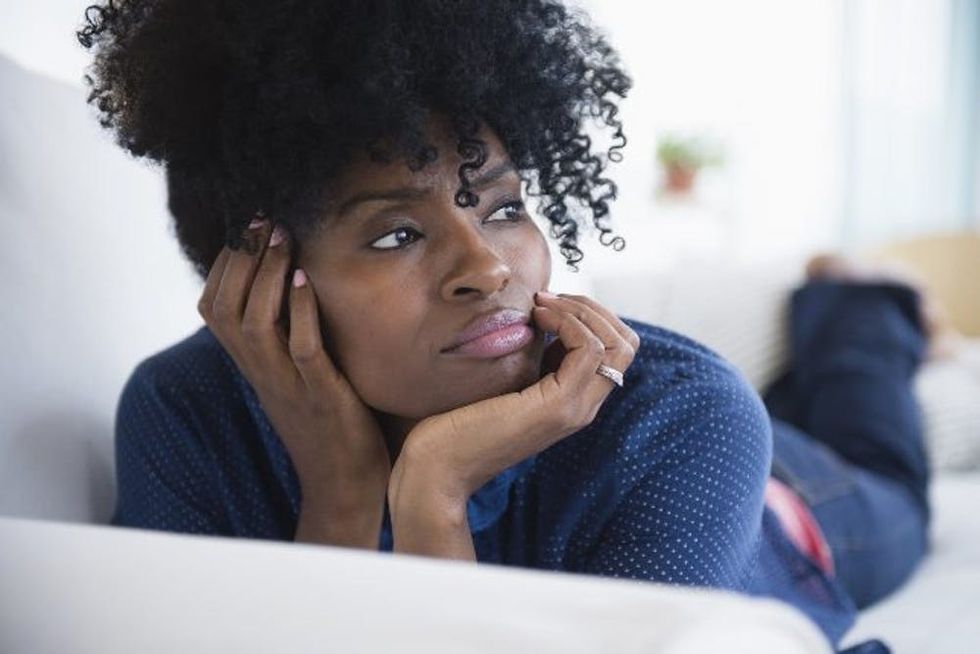 A tired woman lies on a sofa