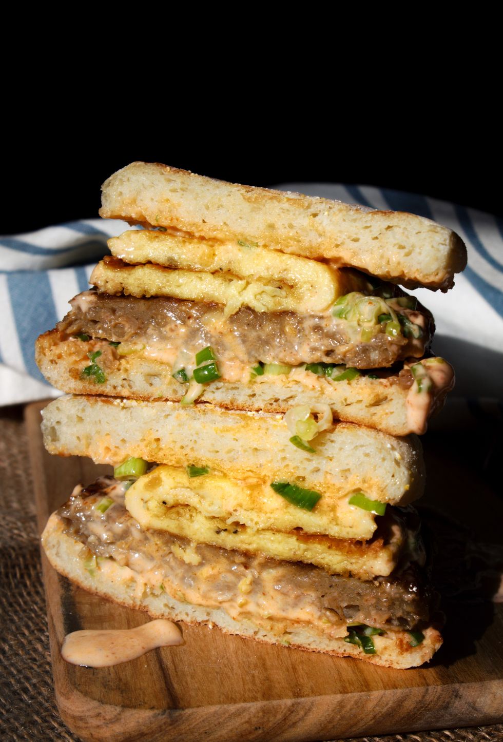 A vegan breakfast sandwich is on a wooden surface.