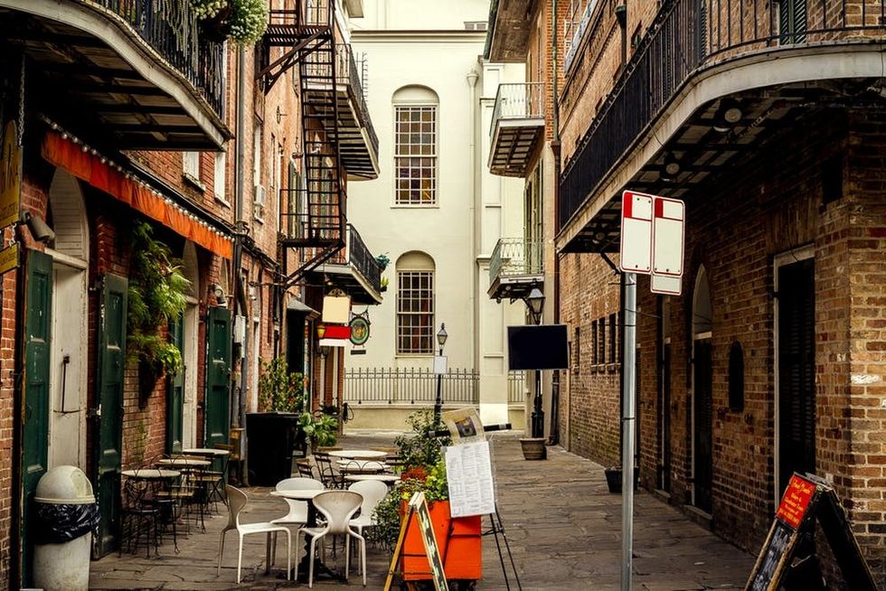 A view down an short alleyway in the French Quarter; which includes a small open air cafe area.