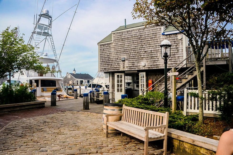 A view of a pedestrian boulevard in Nantucket Island with a marina at the end. Located 50 kms off the coast of Cape Cod, Massachusetts, Nantucket is one of the main tourist attractions in the summer time in Massachusetts, and it is the generally referred in Moby Dick, the book written by Herman Melville about the whaling industry that took place in the second half of the Eighteenth Century, an industry whose main port of sailing was the Port of Nantucket.
