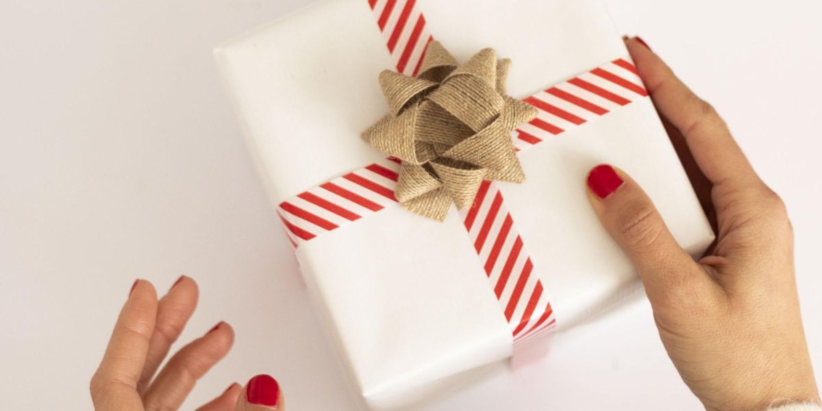 a white present with red and white ribbon wrapping paper hacks