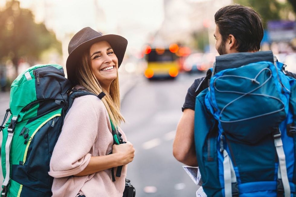 A woman and a man walk through a city