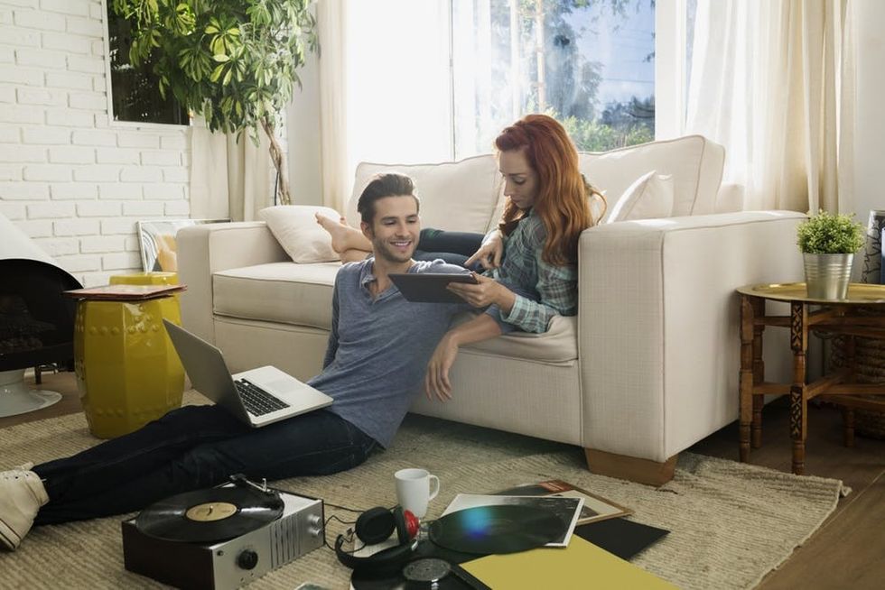 A woman asks a friend about something on her tablet