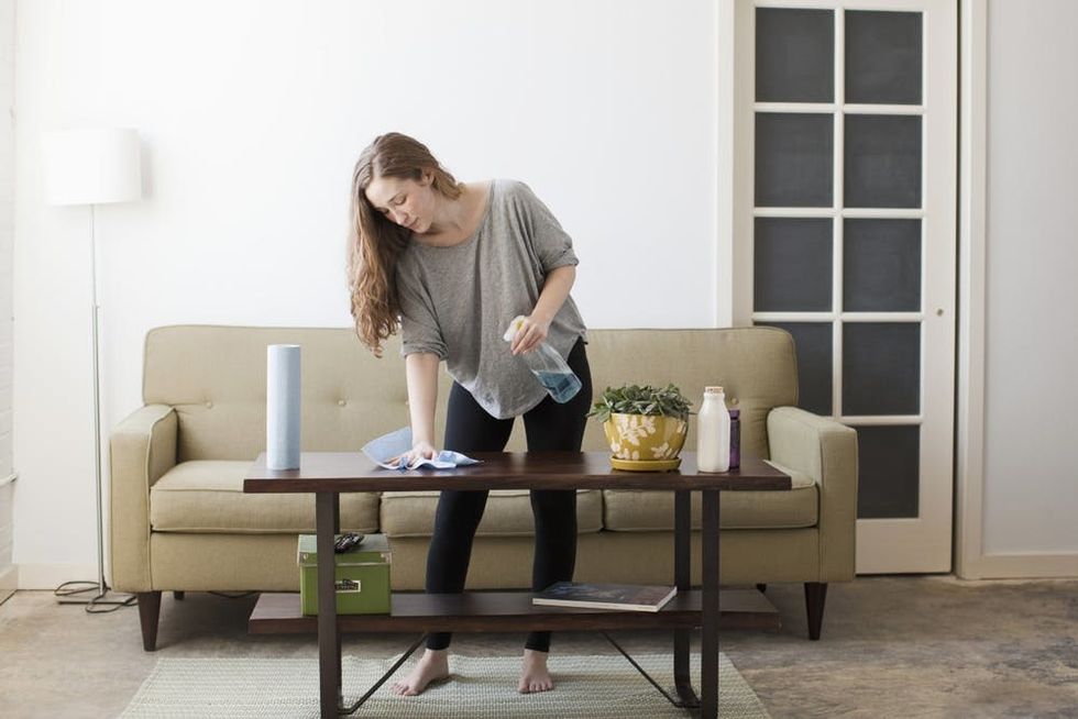 A woman cleans her living room