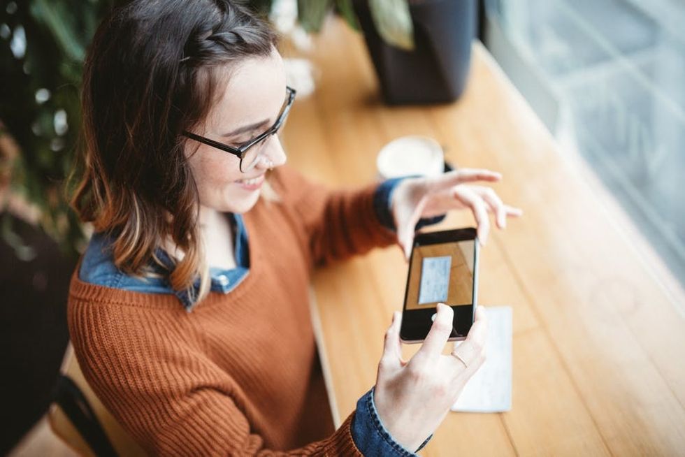 A woman deposits a check using her phone