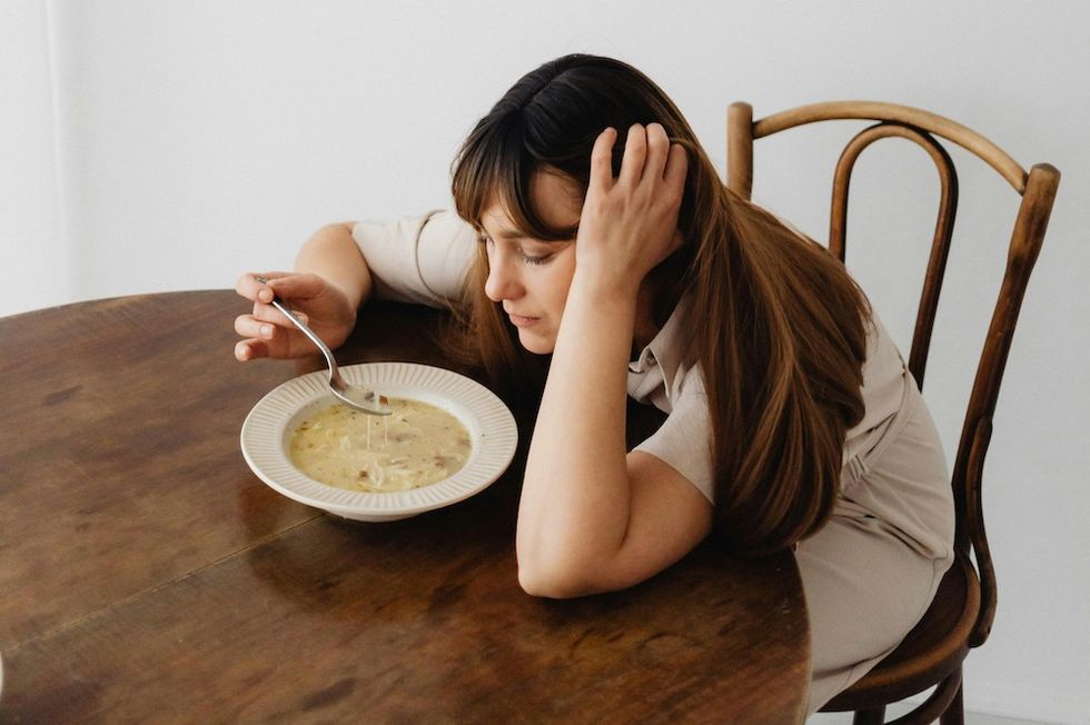 a woman eating chicken soup