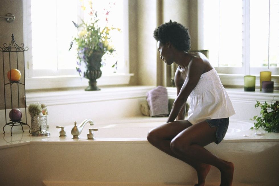 A woman fills a bathtub