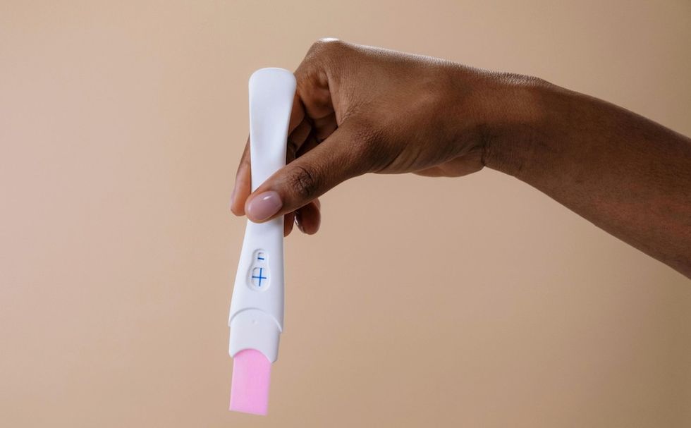 a woman holding a pregnancy test